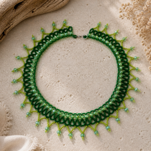 Green beaded collar necklace with layered lace-like beadwork and pointed fringe details.