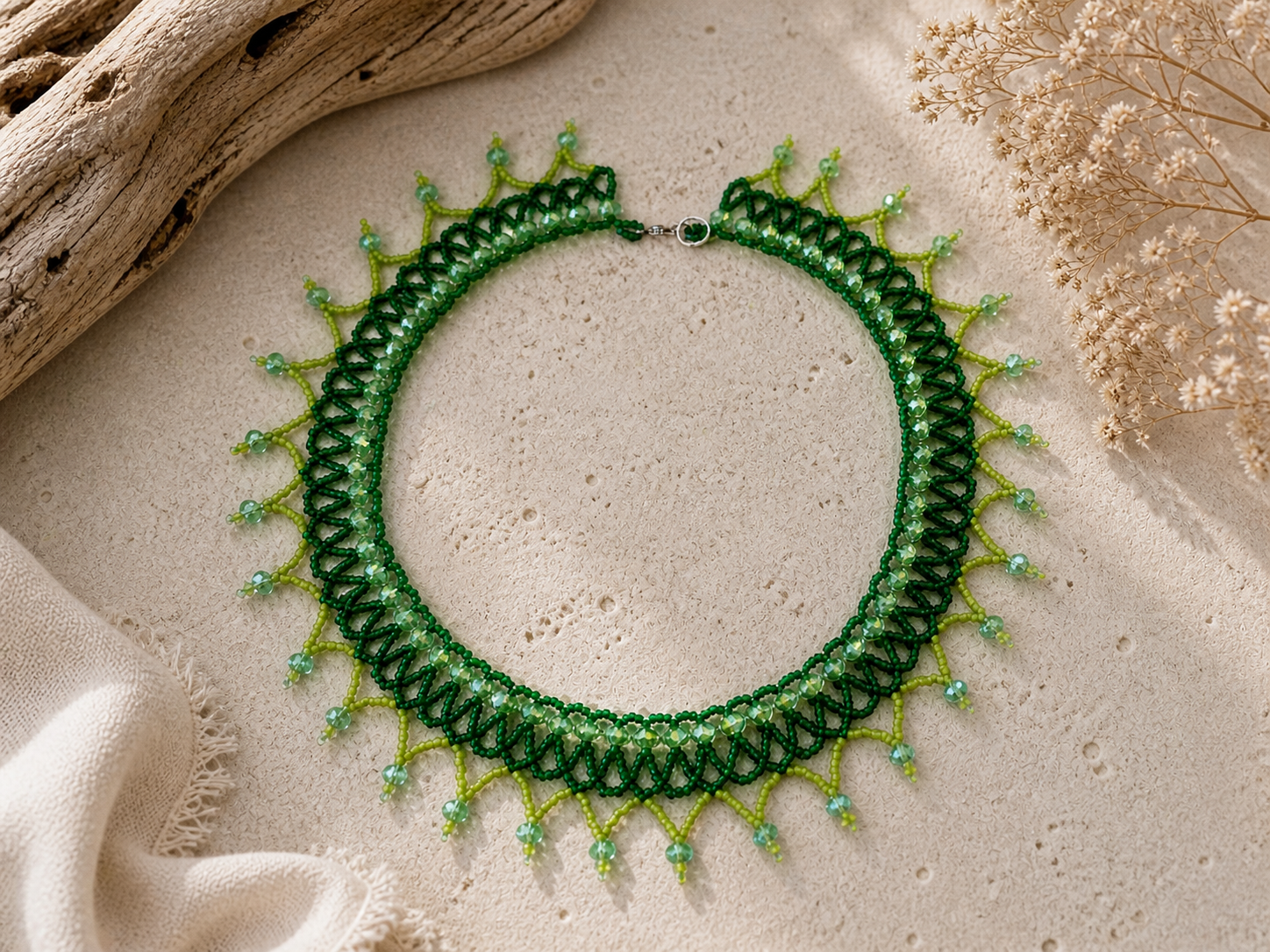Green beaded collar necklace with layered lace-like beadwork and pointed fringe details.