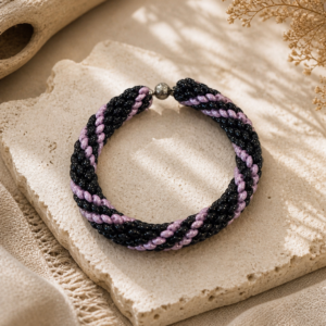 Spiral beadwoven bracelet in glossy black and lavender with magnetic clasp and twisted rope design.