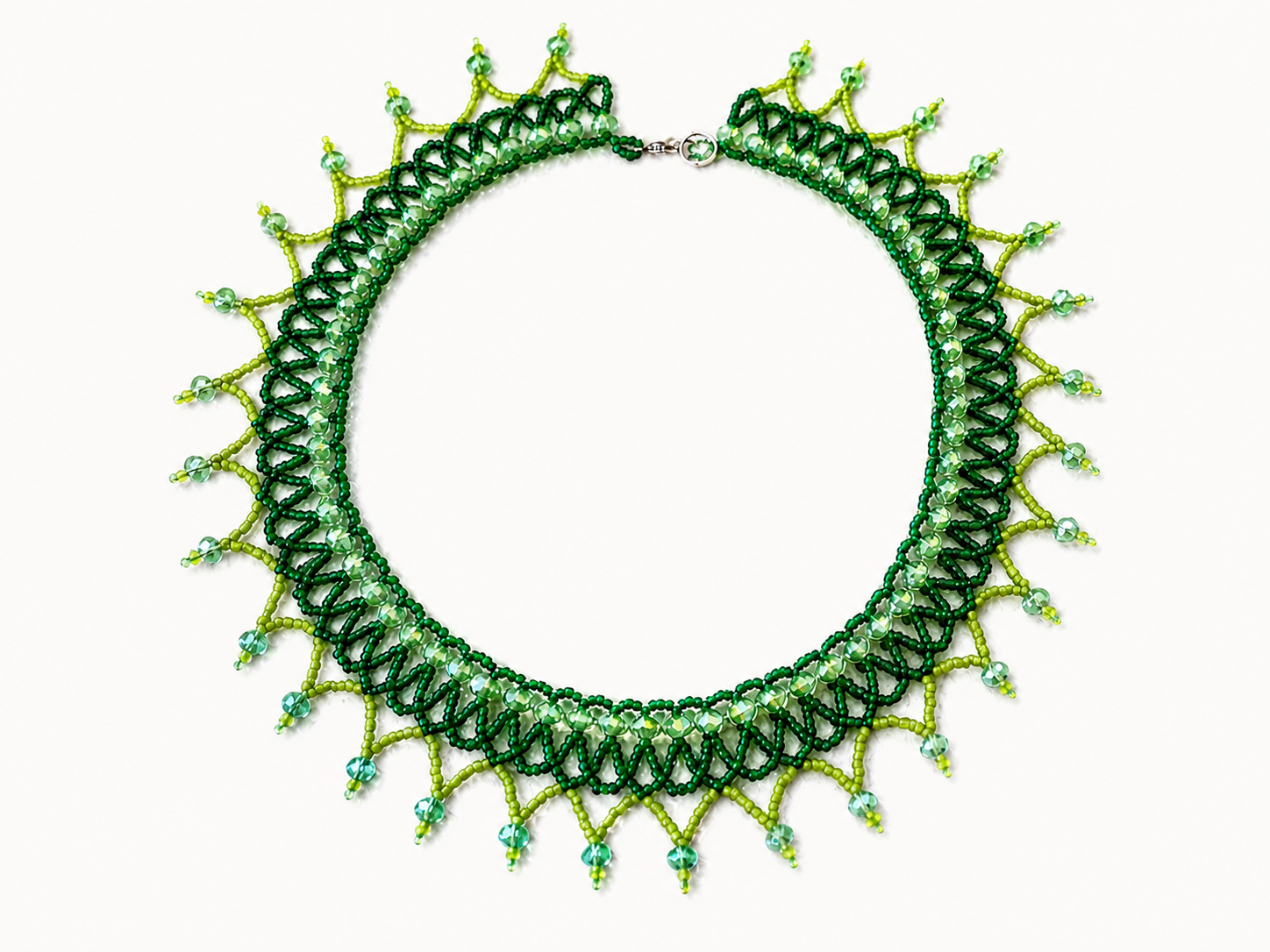 Green beaded collar necklace with layered lace-like beadwork and pointed fringe details.