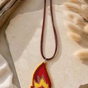 Flame-shaped beaded pendant necklace in red and yellow tones with a black crystal centerpiece on a red cord necklace.
