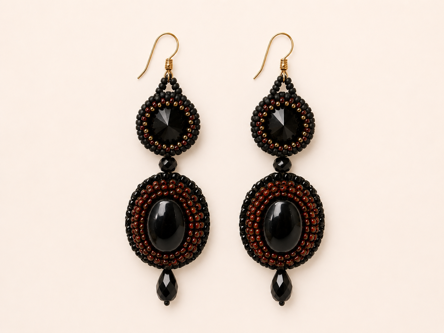 Handcrafted bead embroidered earrings featuring black oval cabochons, black faceted crystals, and intricate black and copper-red seed bead embroidery.