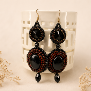 Handcrafted bead embroidered earrings featuring black oval cabochons, black faceted crystals, and intricate black and copper-red seed bead embroidery.