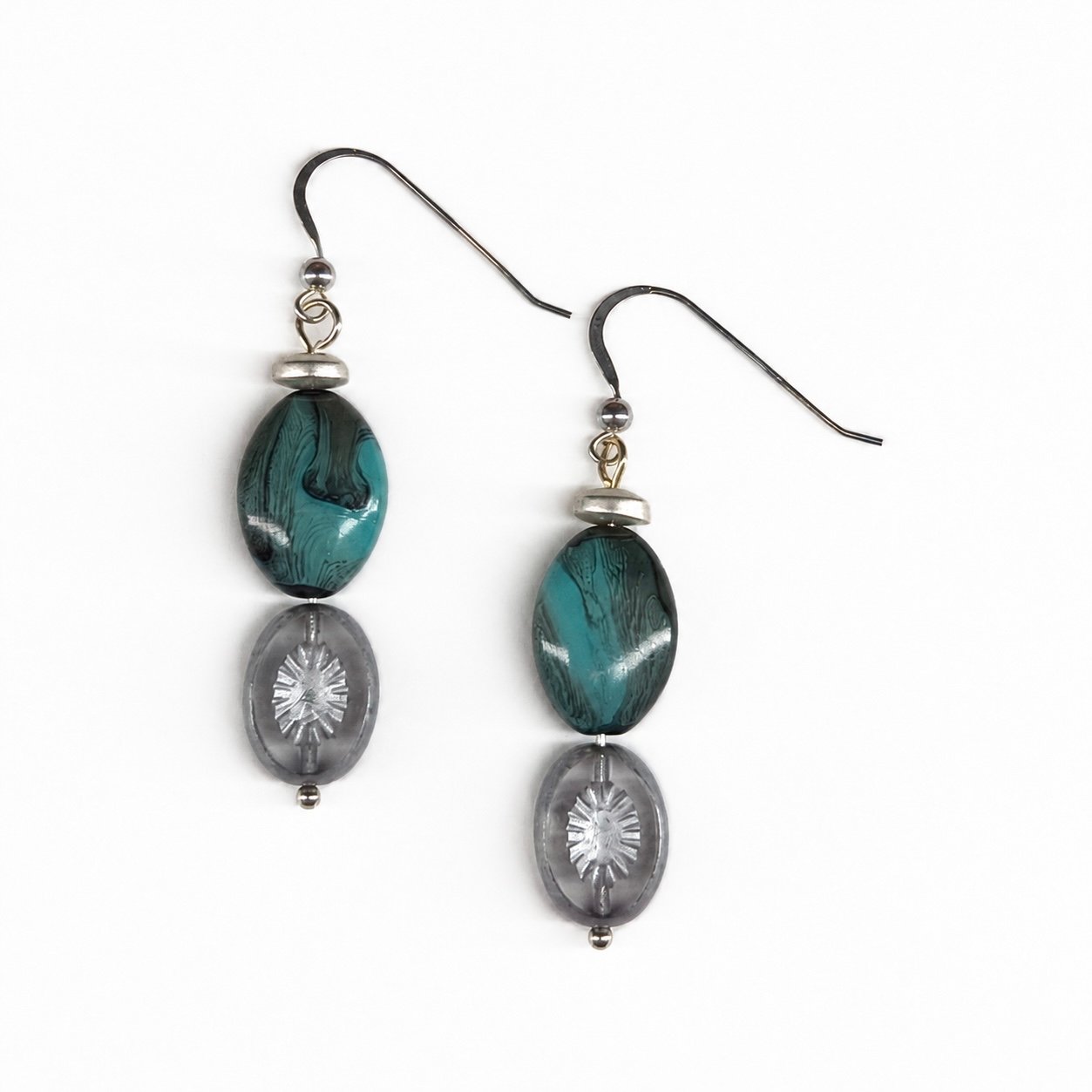 Handcrafted dangle earrings featuring marbled teal glass beads paired with translucent gray etched glass beads and sterling silver ear wires.
