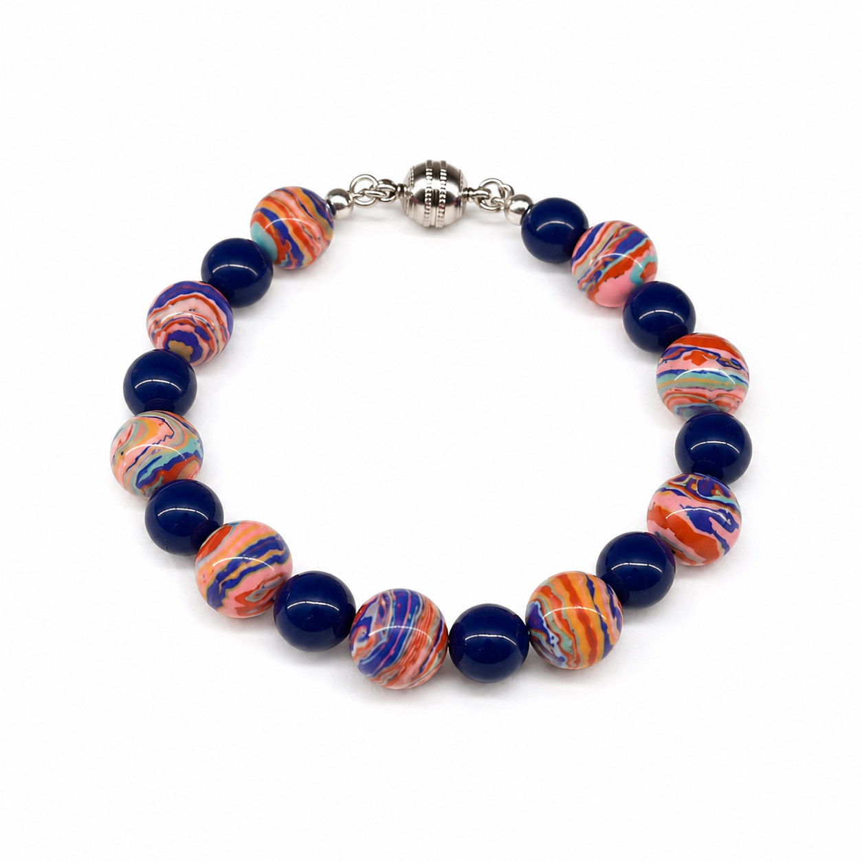 Handcrafted bracelet featuring multicolored artisan beads with swirling coral, blue, lavender, turquoise, and peach patterns, accented with cobalt blue glass beads and a silver magnetic clasp.