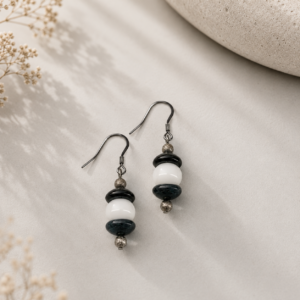 Handcrafted drop earrings featuring navy blue lampwork glass beads, white glass beads, sterling silver accent beads, and silver ear wires.