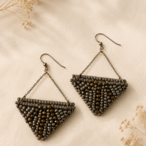 Handwoven triangular earrings featuring graphite gray seed beads, bronze metallic accents, and suspended chain details forming a modern geometric silhouette.