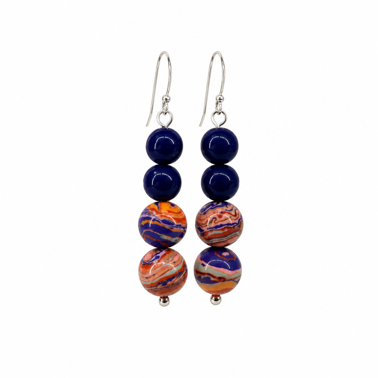 Handcrafted drop earrings featuring cobalt blue glass beads and artisan focal beads swirled with coral, peach, violet, and blue tones on sterling silver ear wires.